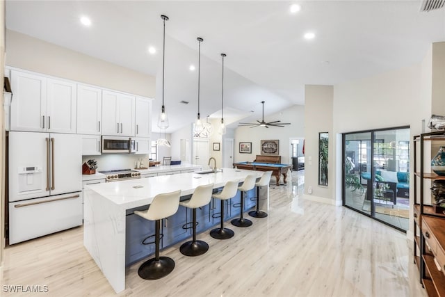 kitchen featuring white cabinets, stainless steel appliances, a center island with sink, decorative light fixtures, and ceiling fan