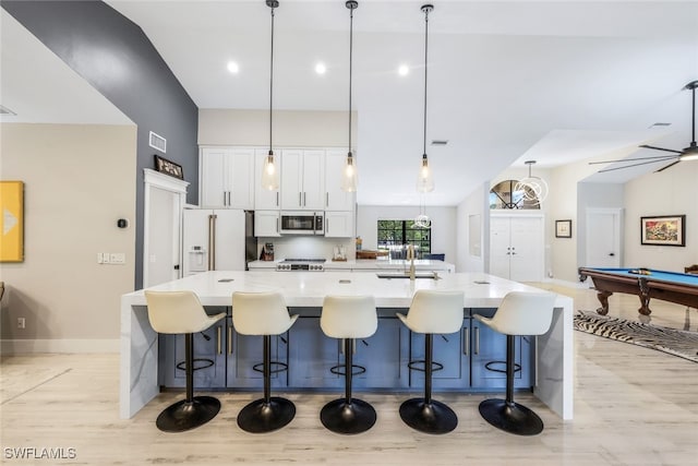 kitchen featuring a kitchen breakfast bar, pendant lighting, stainless steel appliances, pool table, and sink