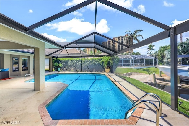 view of swimming pool with glass enclosure and a patio