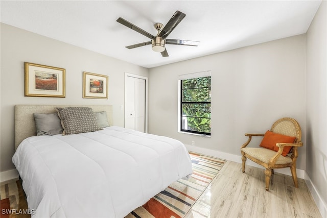 bedroom featuring light hardwood / wood-style flooring, a closet, and ceiling fan