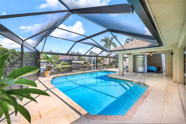 view of swimming pool with a lanai, ceiling fan, and a patio area