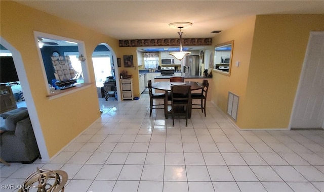 dining space featuring ceiling fan and light tile patterned flooring