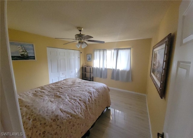 bedroom with ceiling fan, hardwood / wood-style flooring, and a closet