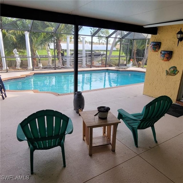 view of swimming pool with glass enclosure and a patio