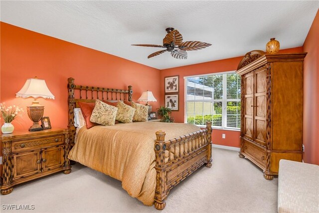 carpeted bedroom featuring a textured ceiling and ceiling fan