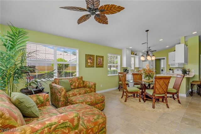 tiled living room featuring ceiling fan with notable chandelier