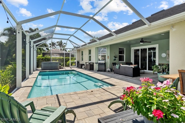 view of swimming pool featuring outdoor lounge area, glass enclosure, ceiling fan, and a patio