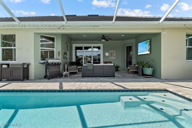 view of swimming pool featuring an outdoor living space, a lanai, a patio area, and ceiling fan