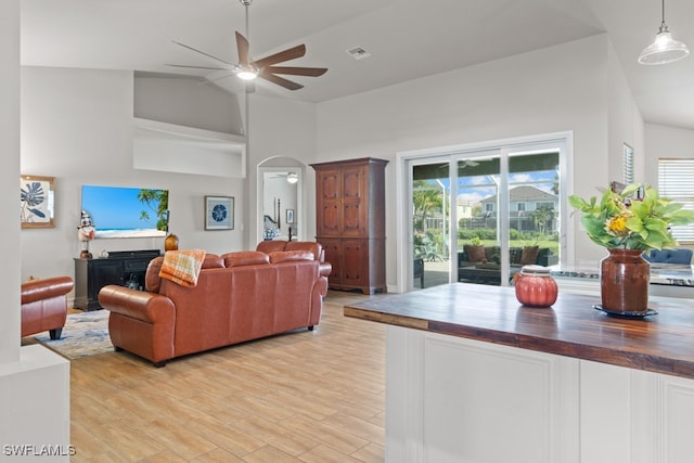 living room featuring light hardwood / wood-style flooring, ceiling fan, and high vaulted ceiling