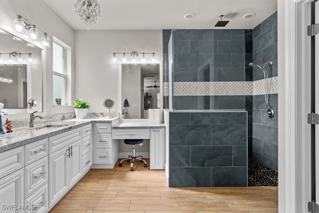 bathroom featuring a tile shower and vanity