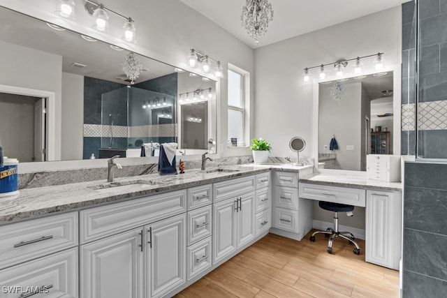 bathroom with vanity, wood-type flooring, and a tile shower