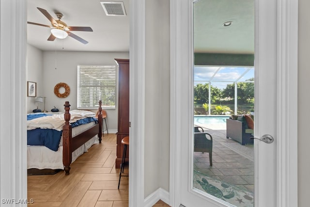 bedroom featuring ceiling fan, multiple windows, and light parquet flooring