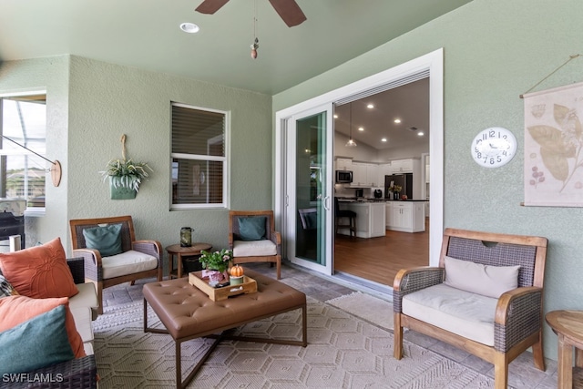 living room featuring ceiling fan and light hardwood / wood-style floors