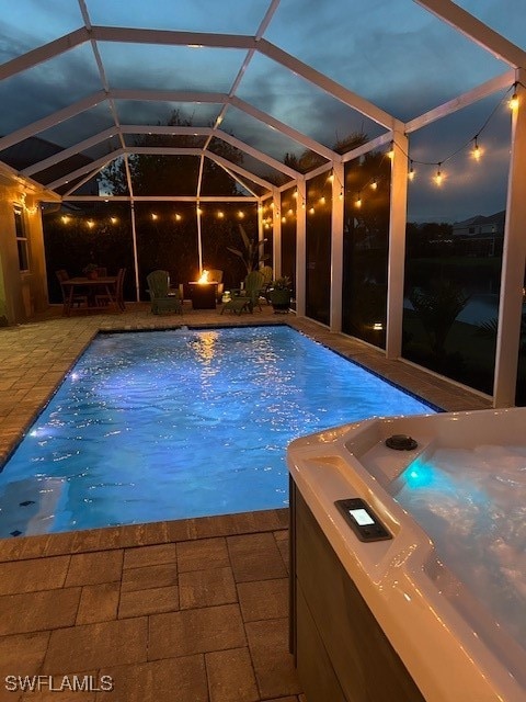 view of pool with a lanai, a patio area, and a hot tub