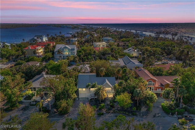 aerial view at dusk featuring a water view