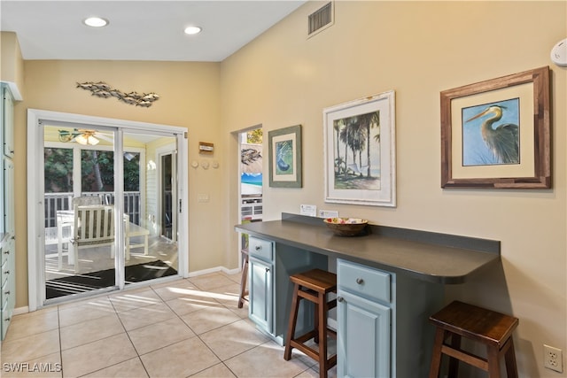 interior space with light tile patterned floors, vaulted ceiling, and ceiling fan