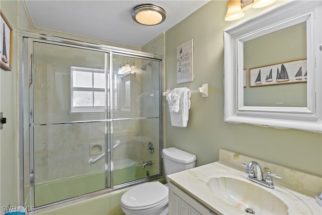 full bathroom with vanity, toilet, and shower / bath combination with glass door