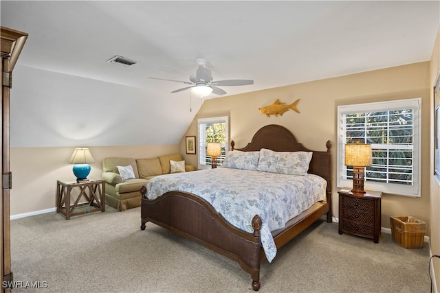 carpeted bedroom with multiple windows, ceiling fan, and vaulted ceiling