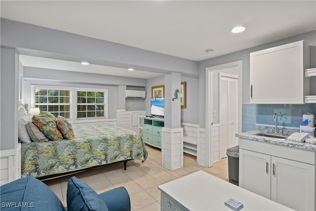 tiled bedroom with a wall mounted AC, a closet, and sink