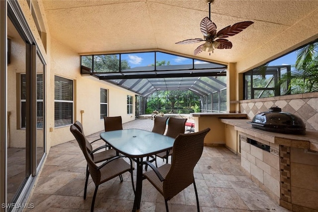 view of patio with ceiling fan and a lanai