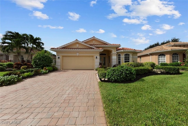 mediterranean / spanish-style home featuring a front yard and a garage