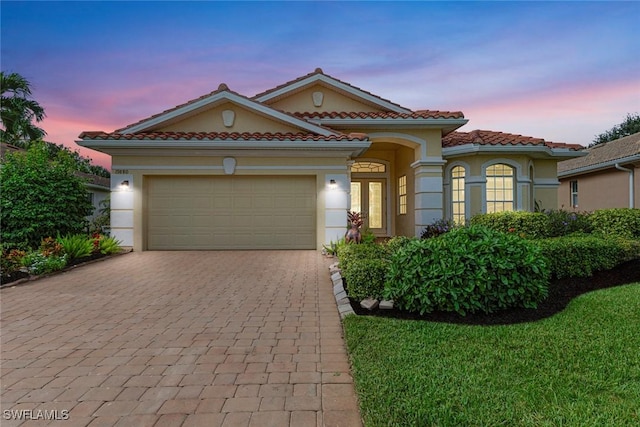 mediterranean / spanish house with a garage and a yard