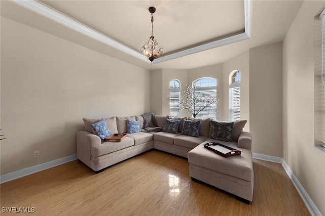 living room featuring a chandelier, a tray ceiling, and hardwood / wood-style flooring