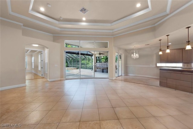 unfurnished living room with a raised ceiling, a towering ceiling, light tile patterned flooring, and ornamental molding