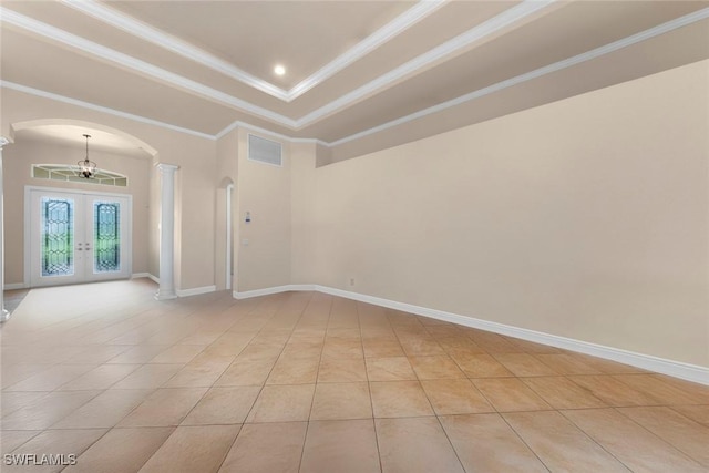 unfurnished room featuring french doors, a tray ceiling, crown molding, light tile patterned floors, and a chandelier