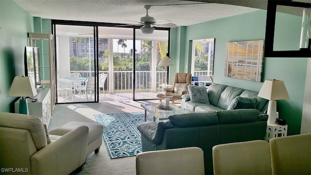 carpeted living room featuring ceiling fan and a textured ceiling