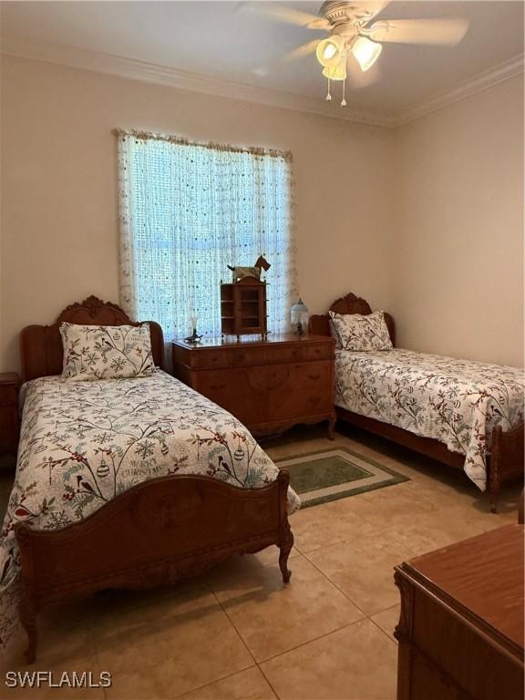 bedroom with tile patterned floors, ceiling fan, and ornamental molding