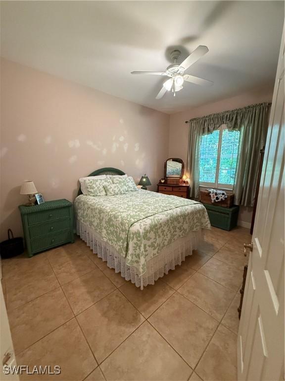 bedroom with ceiling fan and light tile patterned floors