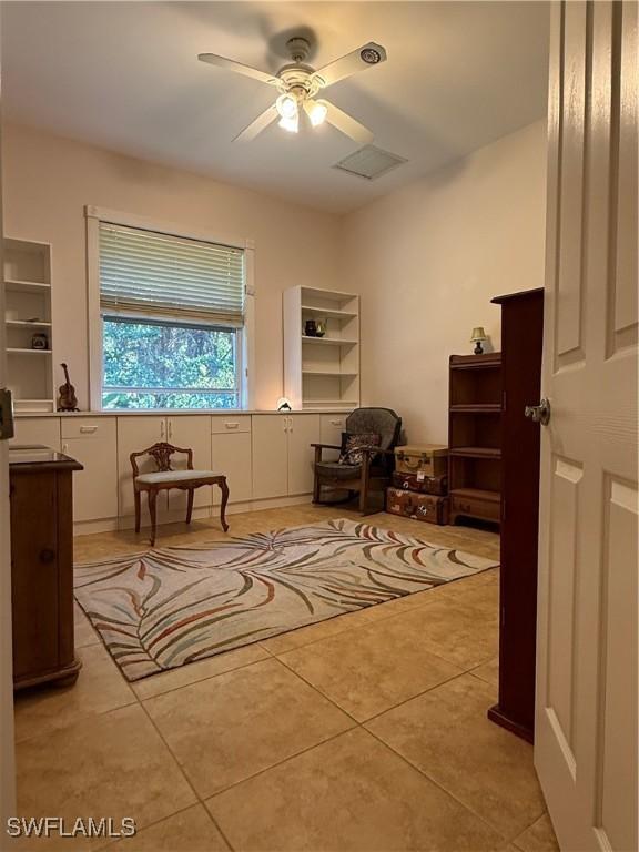 living area with ceiling fan and light tile patterned flooring