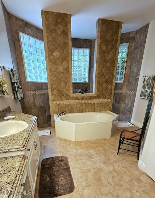 bathroom featuring plus walk in shower, vanity, and tile patterned flooring