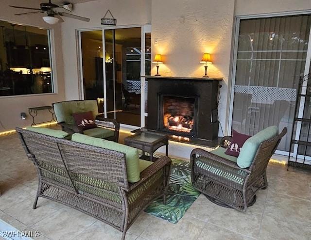 view of patio featuring an outdoor living space with a fireplace and ceiling fan