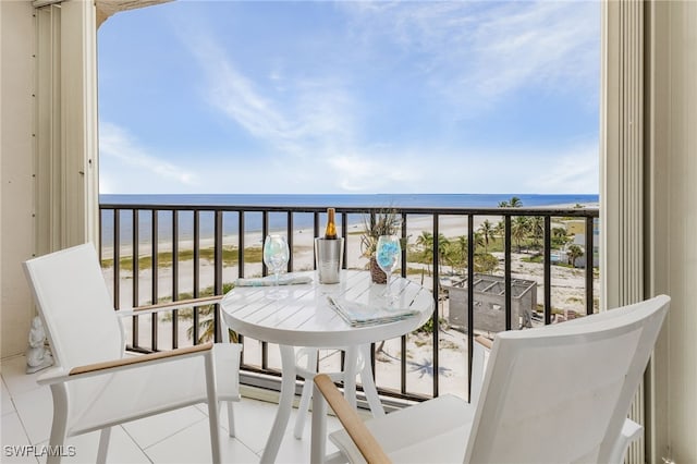 balcony featuring a water view and a beach view