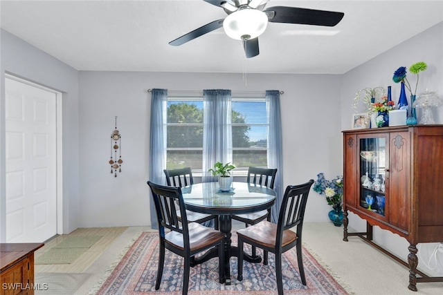 dining area featuring light carpet and ceiling fan