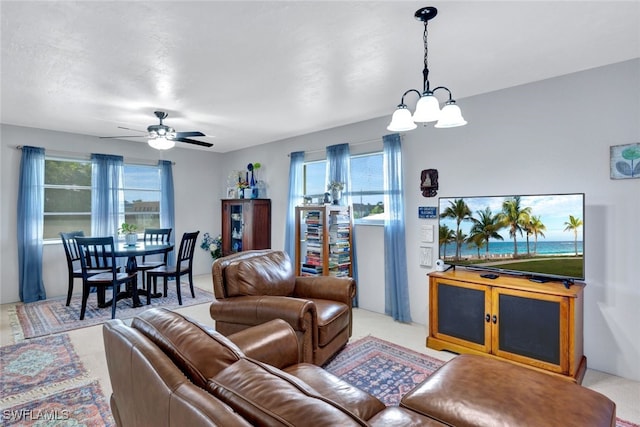 carpeted living room featuring ceiling fan with notable chandelier