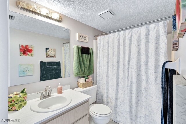 bathroom featuring a textured ceiling, curtained shower, vanity, and toilet