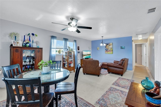 dining space with ceiling fan and light wood-type flooring