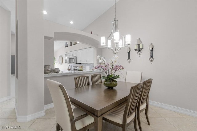 tiled dining room featuring vaulted ceiling and a notable chandelier