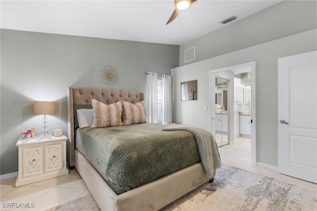 bedroom with light tile patterned flooring, ceiling fan, and ensuite bath