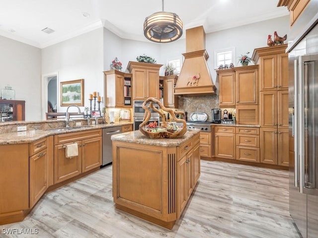 kitchen featuring appliances with stainless steel finishes, light wood-type flooring, decorative light fixtures, ornamental molding, and sink