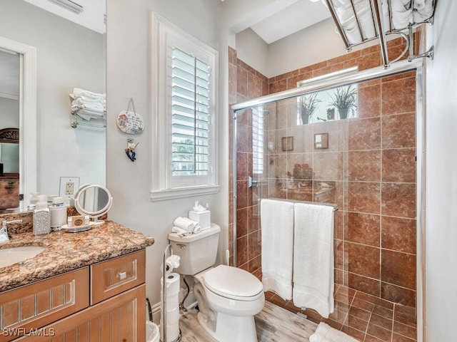 bathroom featuring walk in shower, vanity, and toilet