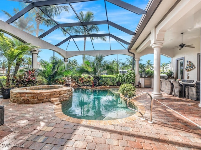 view of pool with glass enclosure, an in ground hot tub, ceiling fan, and a patio