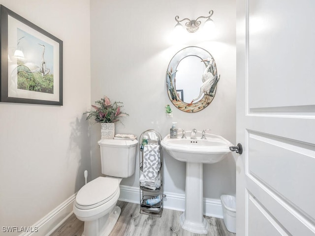 bathroom featuring wood-type flooring and toilet