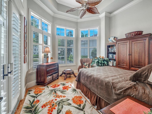 bedroom with light wood-type flooring, multiple windows, ceiling fan, and crown molding