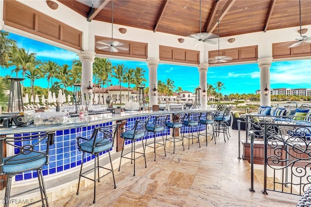 view of patio with ceiling fan and an outdoor bar