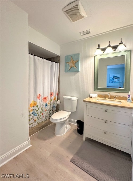 bathroom with toilet, walk in shower, vanity, and wood-type flooring