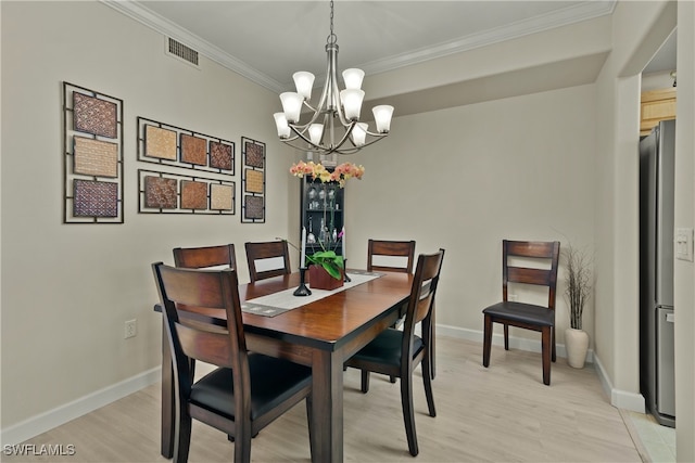 dining room featuring a notable chandelier, crown molding, and light hardwood / wood-style floors